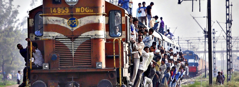 Passengers travel on an overcrowded train at Loni town in Uttar